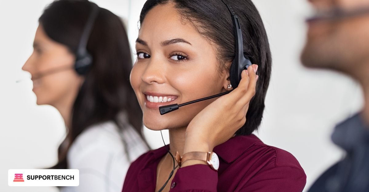 A woman sits at a desk with a laptop and phone, focusing on omnichannel customer support and sentiment analysis