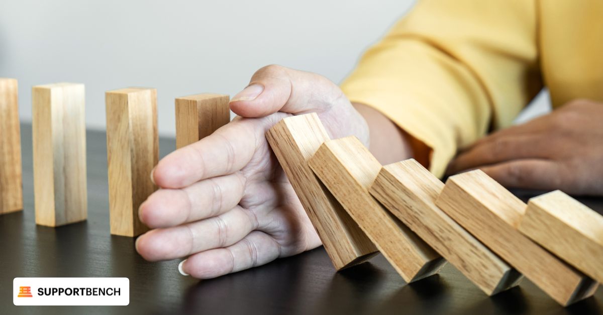 A man uses his hand to stop wooden blocks from falling, symbolizing churn prevention workflows