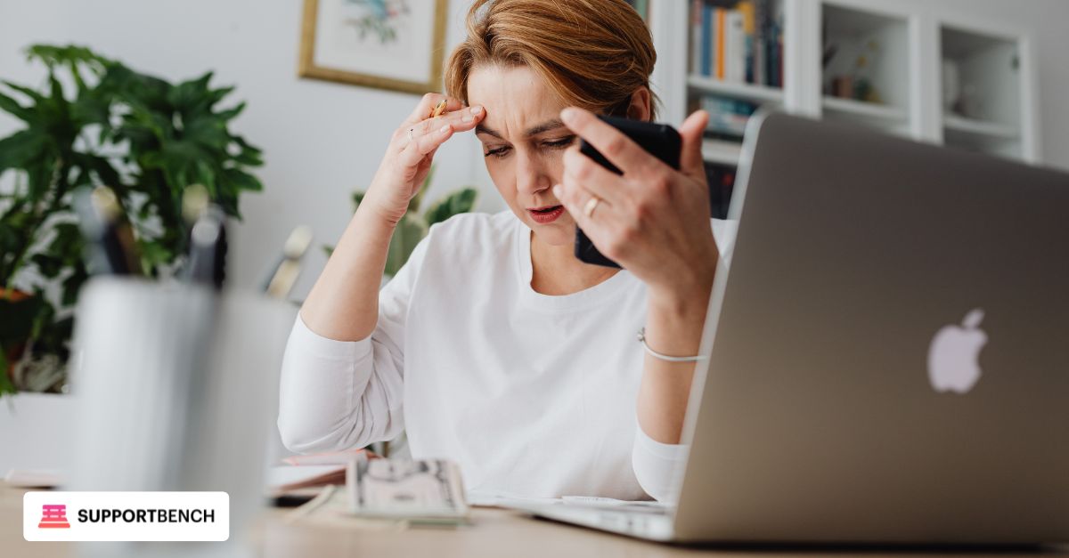 A worried employee on the phone next to a laptop showing no response