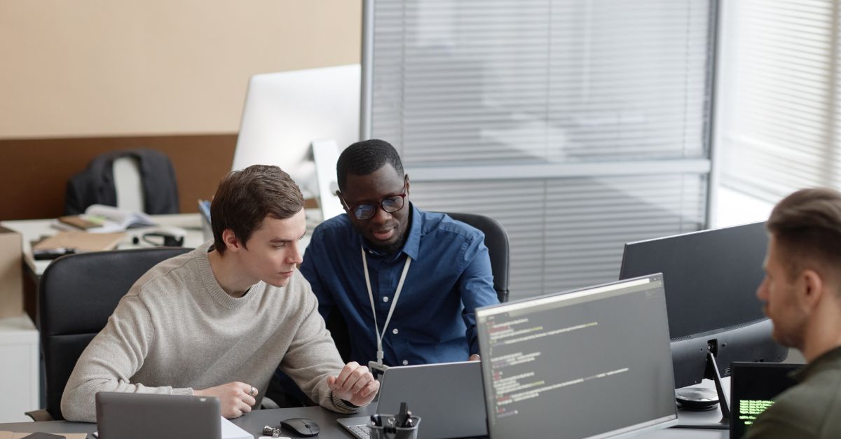 A manager guiding a new IT team member through the helpdesk software during training Similar