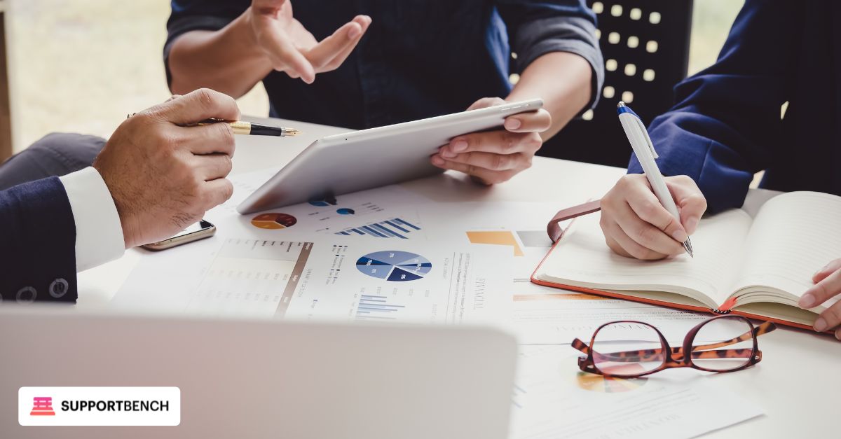 A business manager reviewing helpdesk performance reports with a client in an office meeting