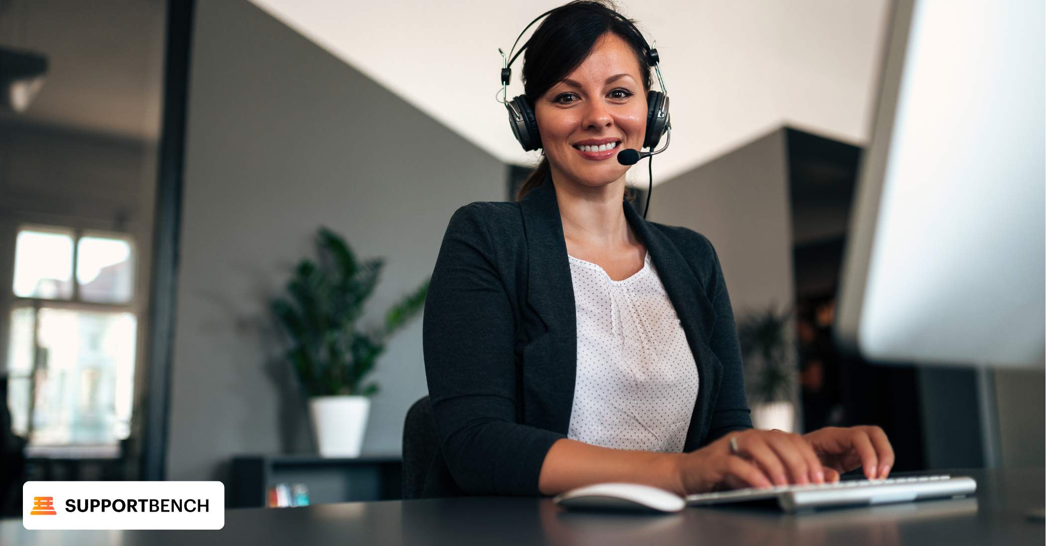 A woman at her desk, utilizing a laptop and phone, exemplifying proactive customer service in her professional environment.